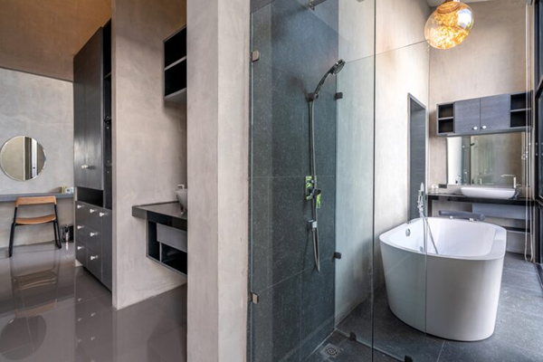 Luxurious walk-in closet with white custom shelving, a center island, hardwood floors, and a crystal chandelier.