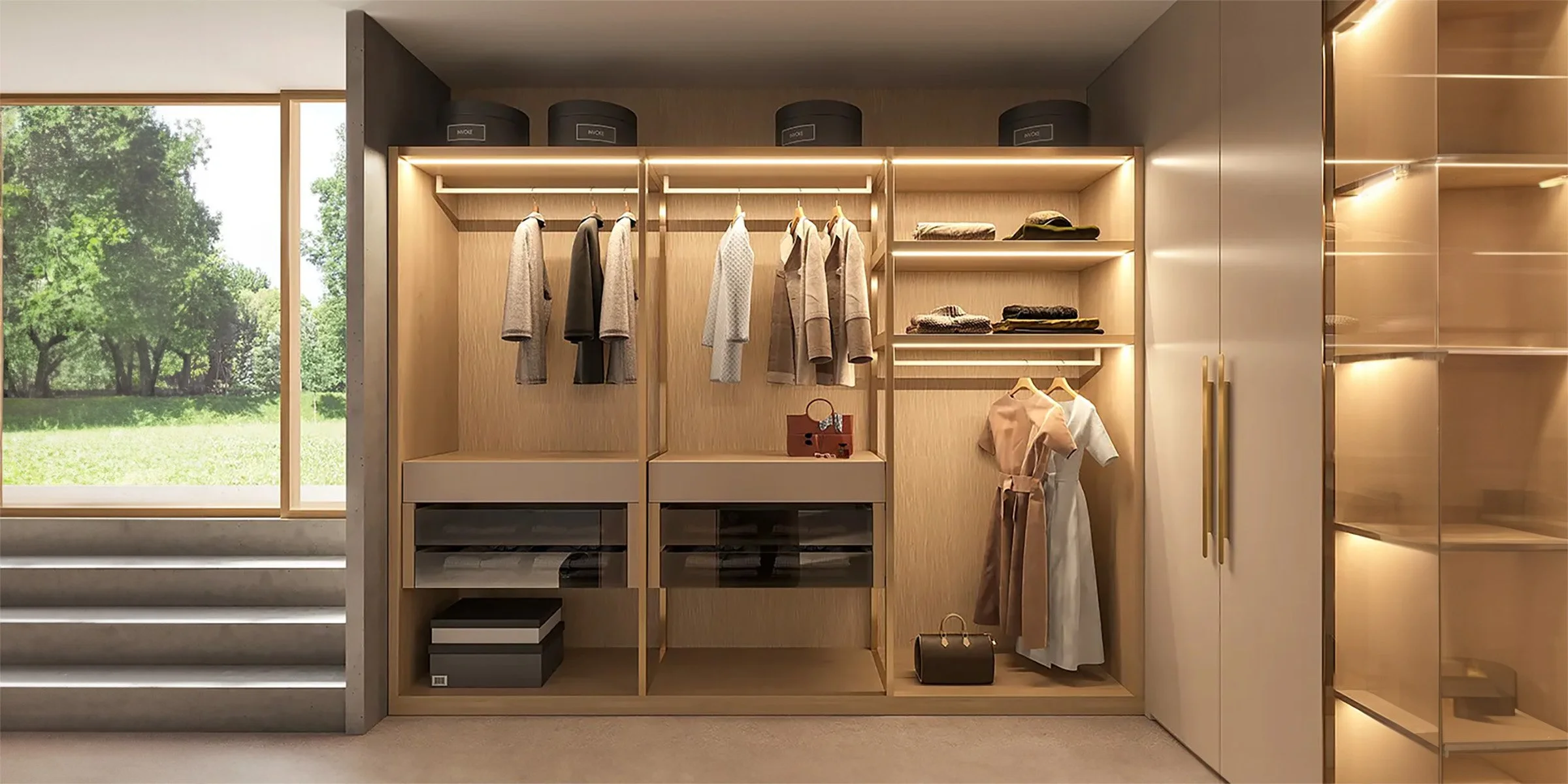 Modern walk-in closet with built-in wooden shelves and warm LED lighting, showcasing neatly hung clothes, folded garments, and luxury
accessories near a large window overlooking a green outdoor view.